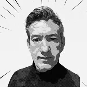 Portrait buste N&B de Luc, cheveux courts, pull foncé fond neutre, Gérant de l'équipe Yescom à Pontivy.