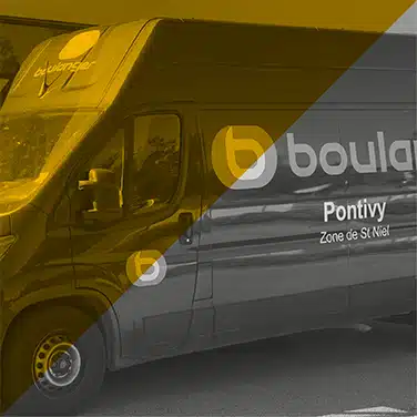 Image en noir & blanc avec aplat jaune en transparence, Camionnette noire floquée avec logo Boulanger et mention « Pontivy Zone de St Niel »